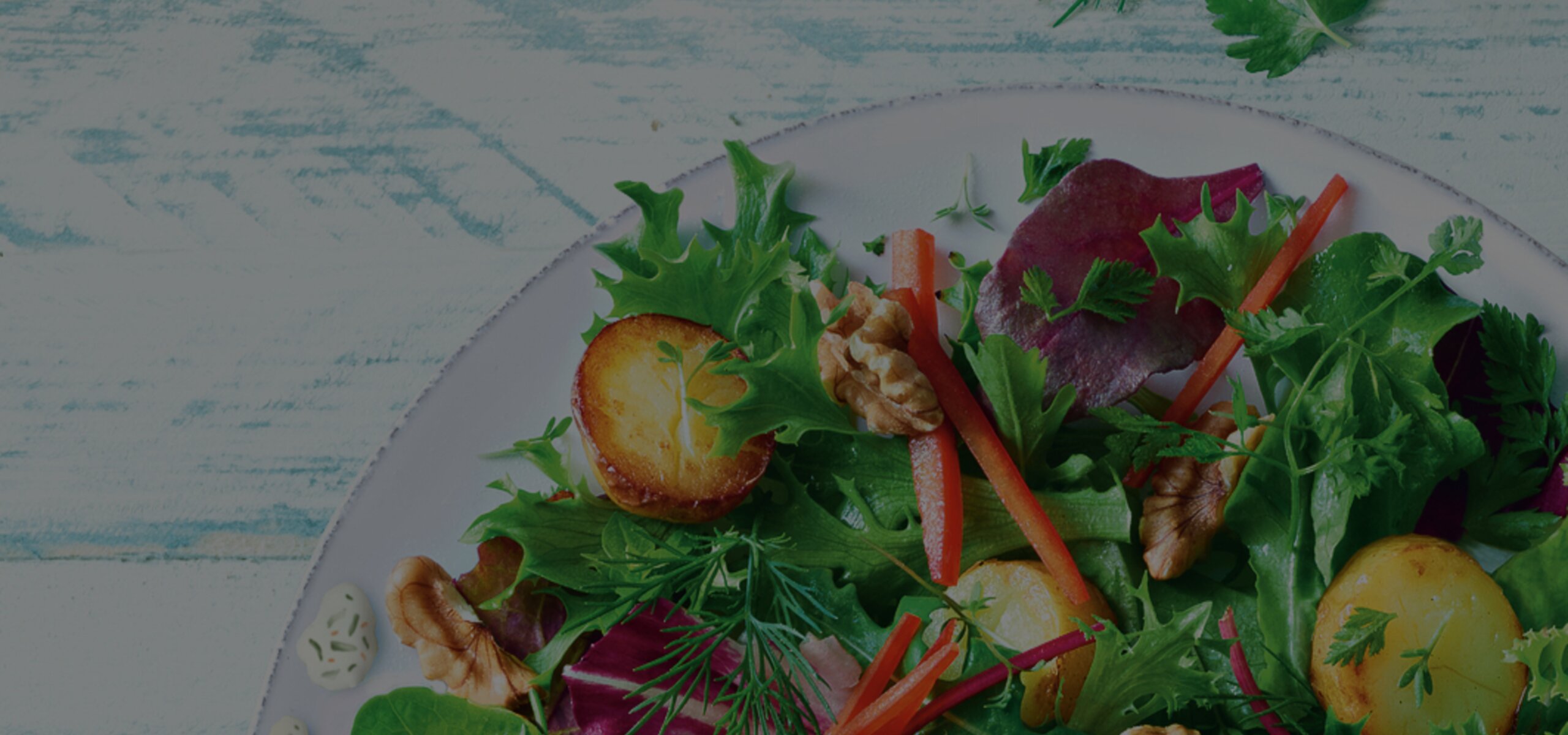 Salat als Hintergrundbild für das Gartenkräuter Dressing von Develey