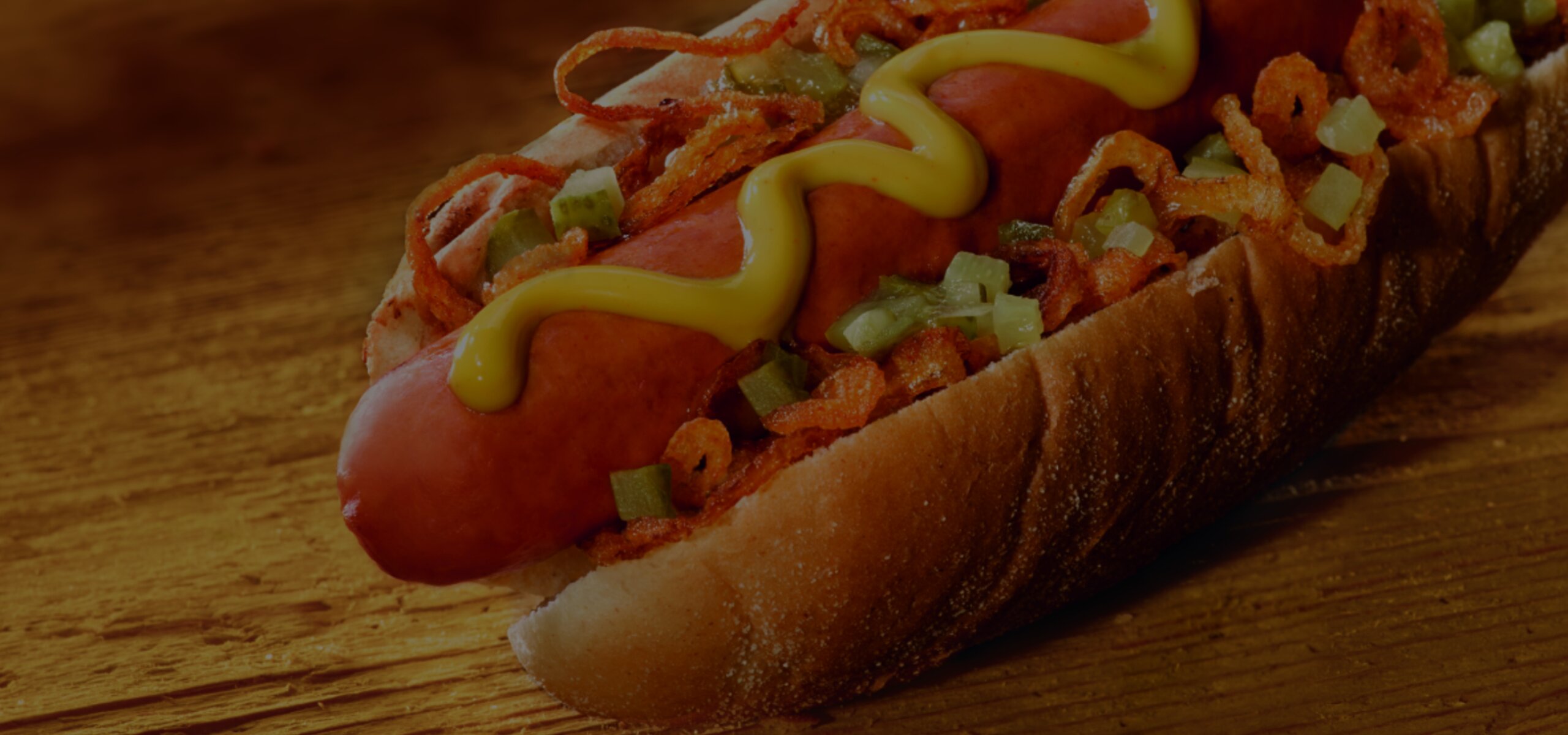 Hintergrundbild Hot-Dog mit Gurken, Senf, Ketchup, Hot-Dog Sauce, Wurst